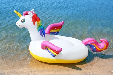 Photo of Funny inflatable unicorn ring near sea on sunny day