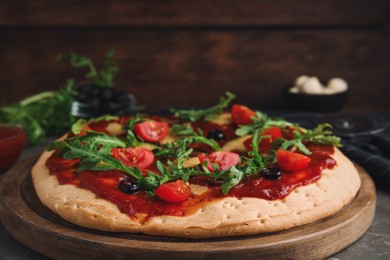 Pita pizza with cheese, olives, tomatoes and arugula on grey table, closeup