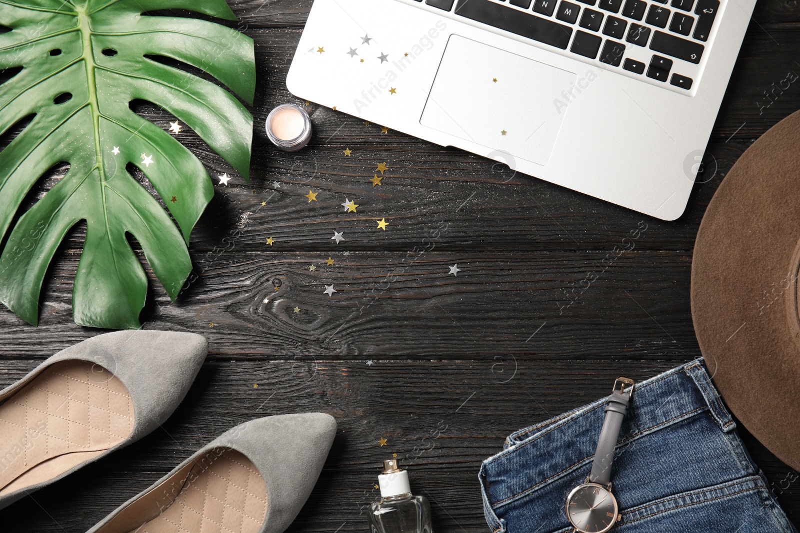 Photo of Flat lay composition with laptop and stylish clothes on wooden table, space for text. Blogger's workplace