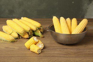 Tasty sweet corn cobs on wooden table