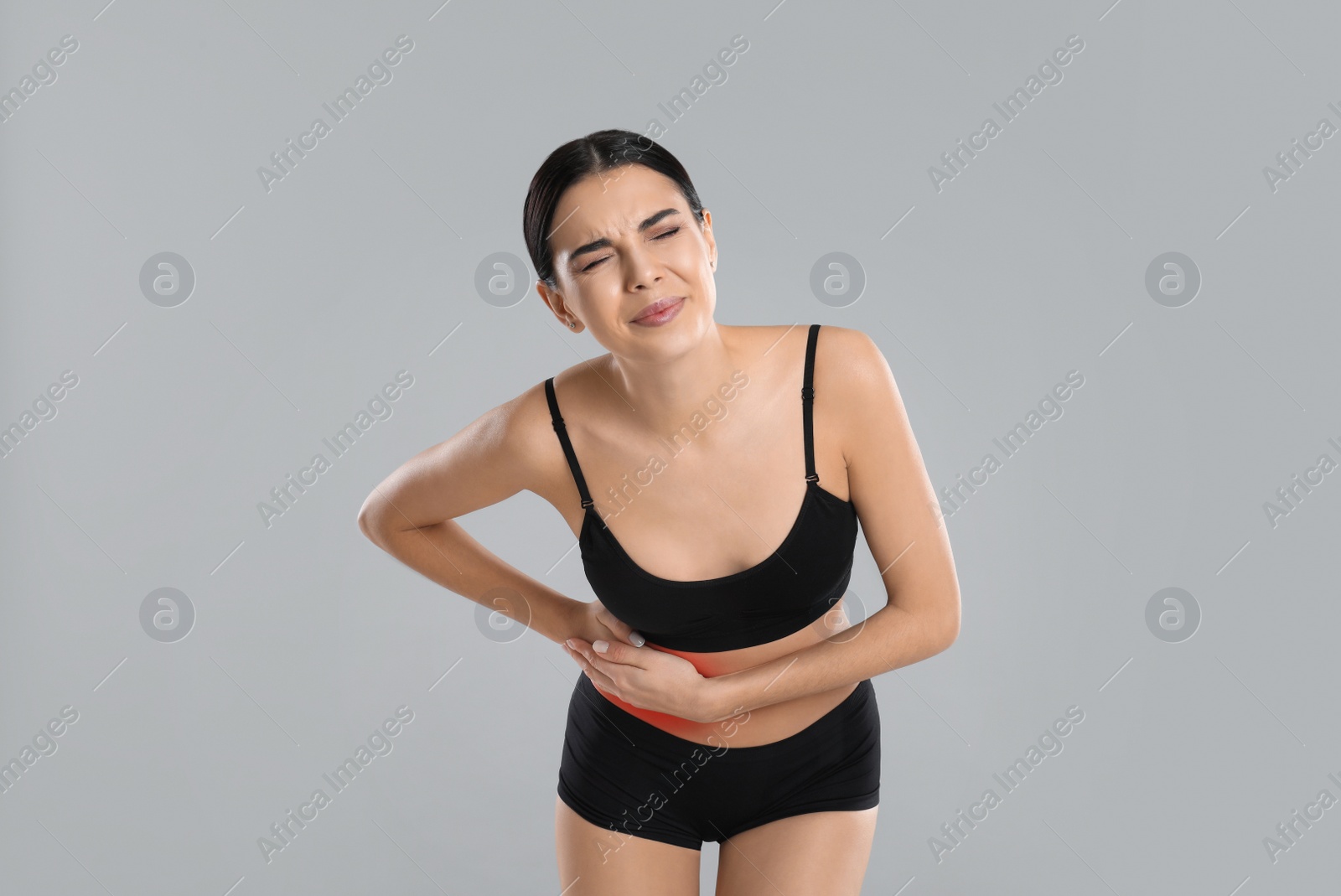 Photo of Woman suffering from liver pain on grey background