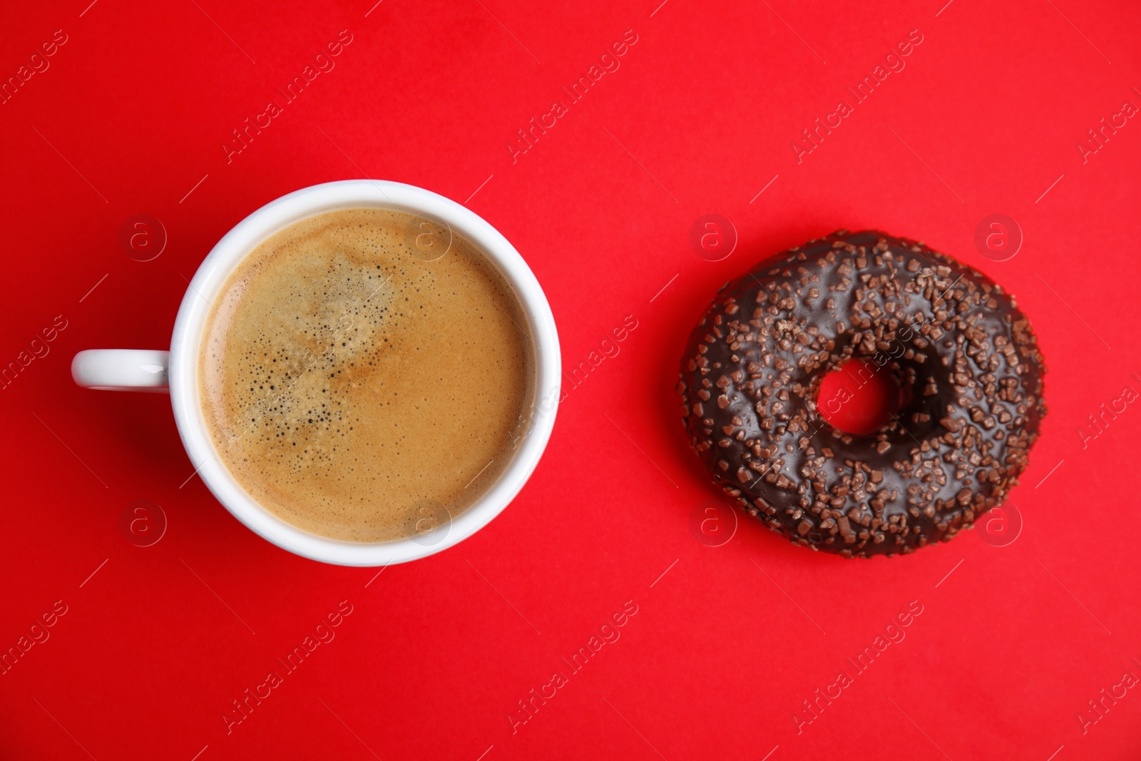 Photo of Delicious coffee and donut on red background, flat lay. Sweet pastries