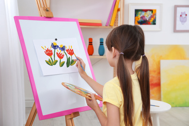 Photo of Cute little child painting during lesson in room