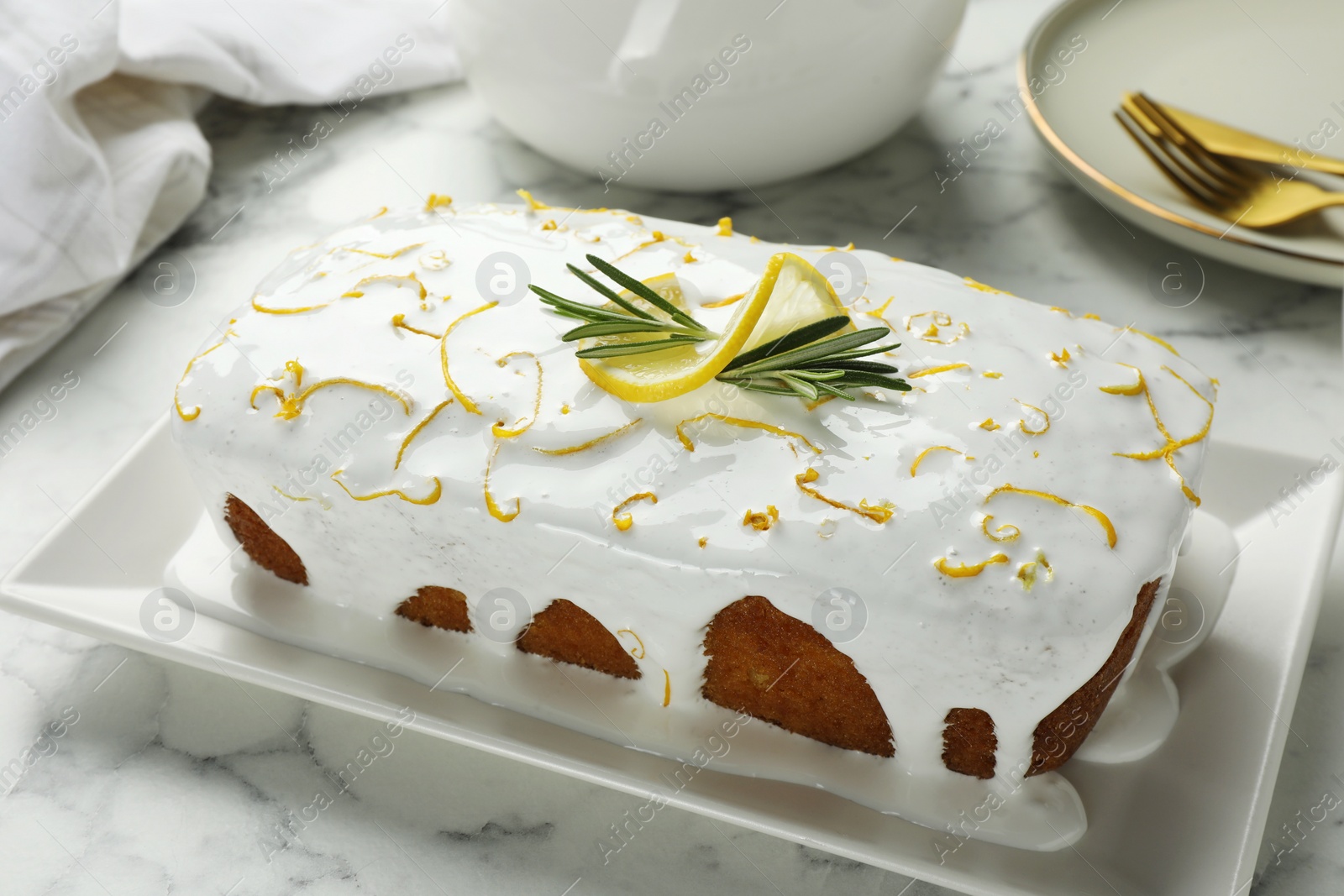 Photo of Tasty lemon cake with glaze on white marble table, closeup