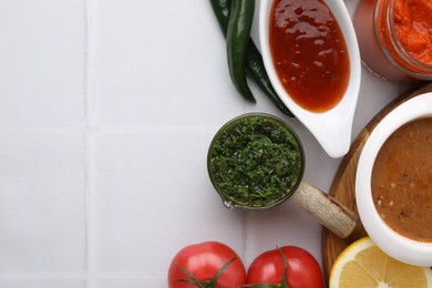 Photo of Different marinades and products on white tiled table, flat lay. Space for text