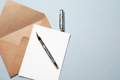 Photo of Blank sheet of paper, letter envelope and pen on grey background, top view. Space for text