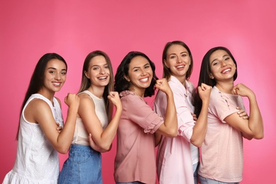 Photo of Happy women posing on pink background. Girl power concept