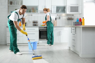 Photo of Cleaning service team at work in kitchen