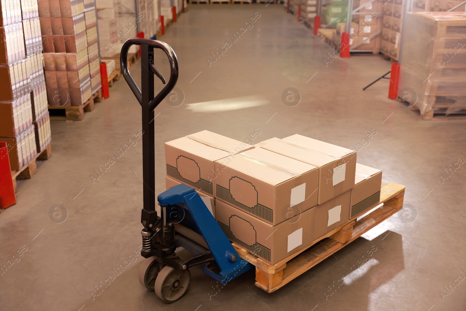 Image of Manual forklift with cardboard boxes in warehouse. Logistics concept