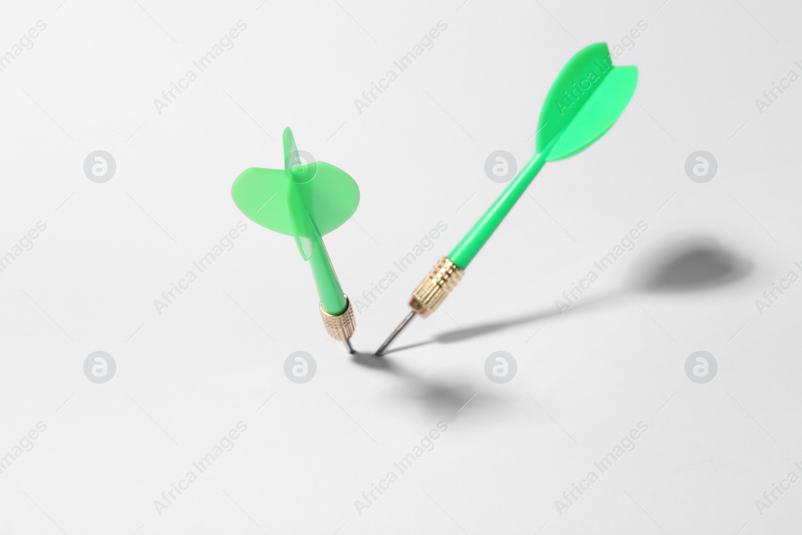 Photo of Green dart arrows for game on white background