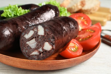 Photo of Tasty blood sausages served on white wooden table, closeup