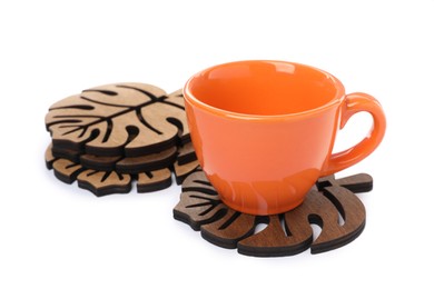 Photo of Leaf shaped wooden coasters and cup on white background