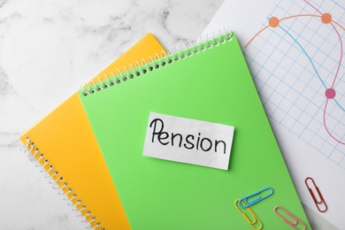 Photo of Paper with word Pension, notebooks and chart on table, top view