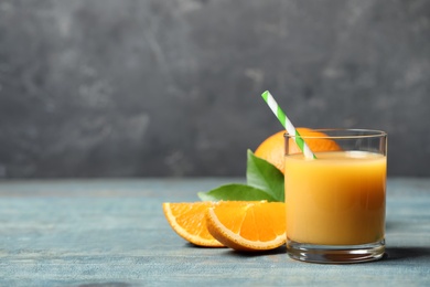 Glass of orange juice and fresh fruits on wooden table. Space for text