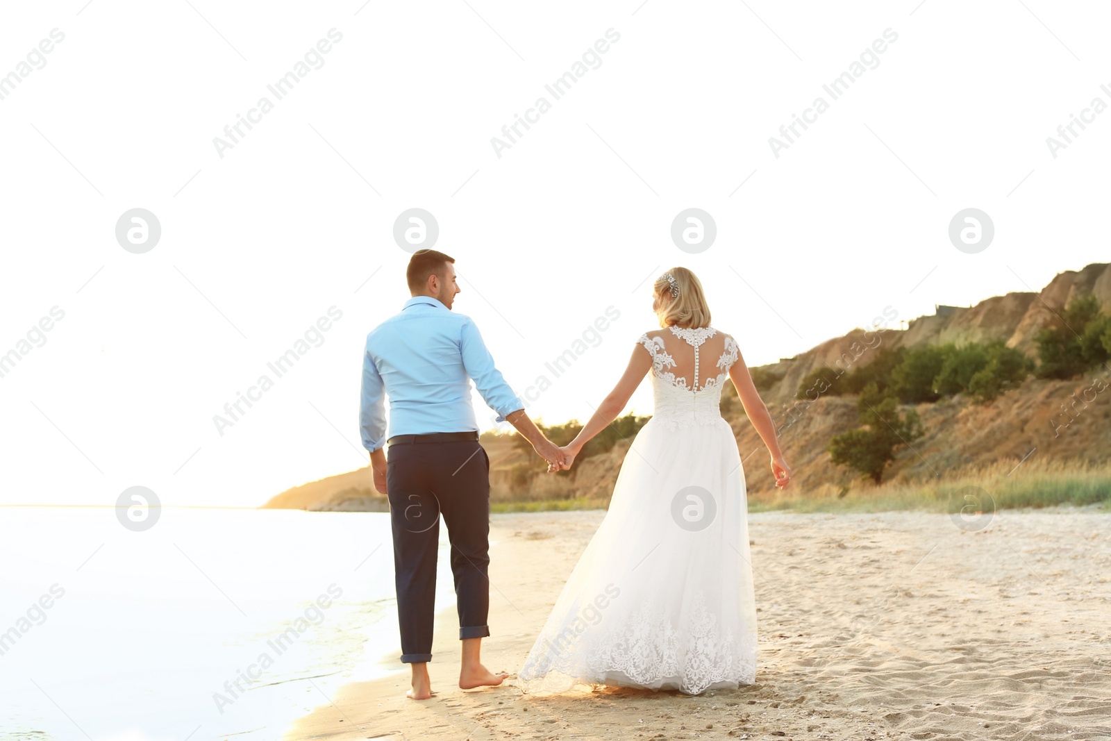 Photo of Wedding couple holding hands together on beach