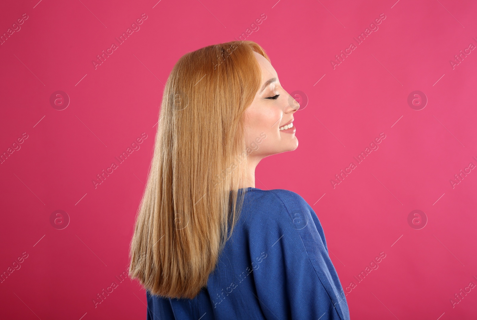 Photo of Beautiful young woman with blonde hair on pink background