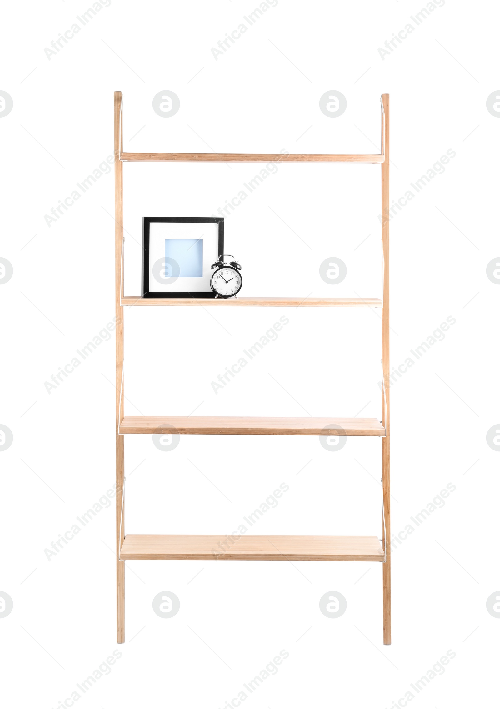 Photo of Wooden shelving unit with photo frame and alarm clock isolated on white