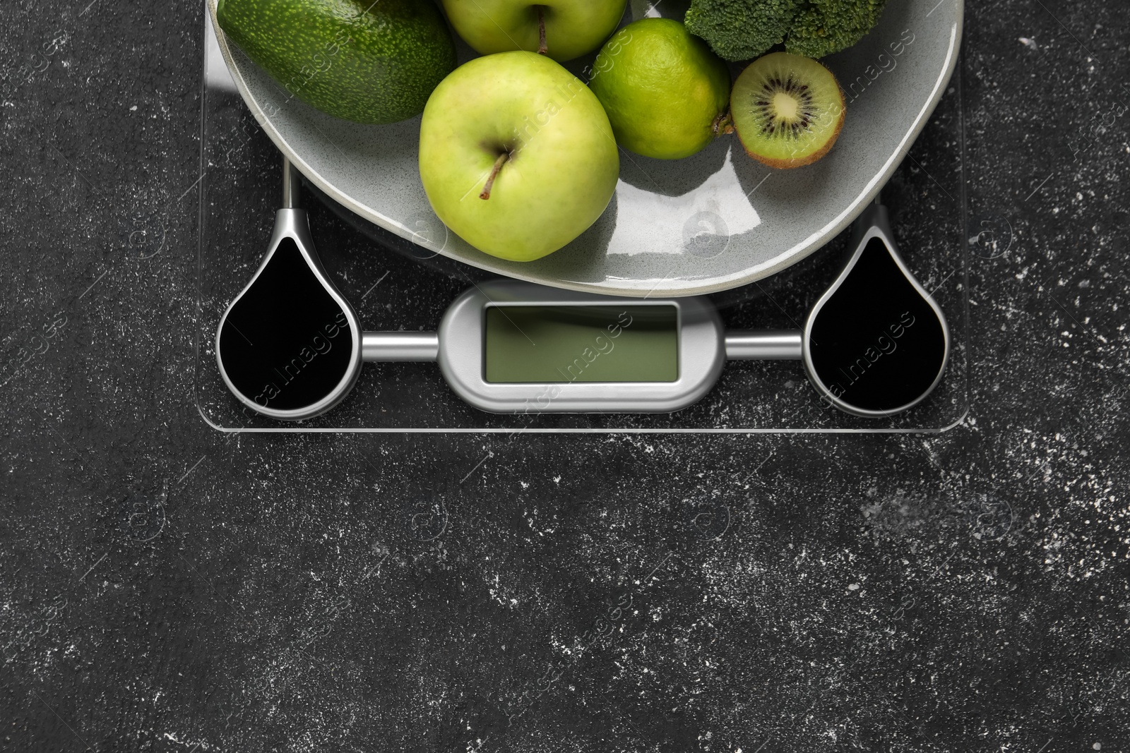 Photo of Healthy diet. Scale and fresh products on black textured table, top view with space for text