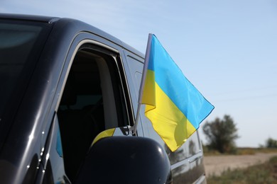 National flag of Ukraine on car window outdoors, closeup
