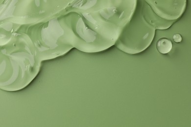 Clear cosmetic gel on light green background, top view. Space for text