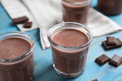 Photo of Delicious chocolate milk on light blue wooden table