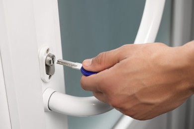 Photo of Man unlocking door with key, closeup view