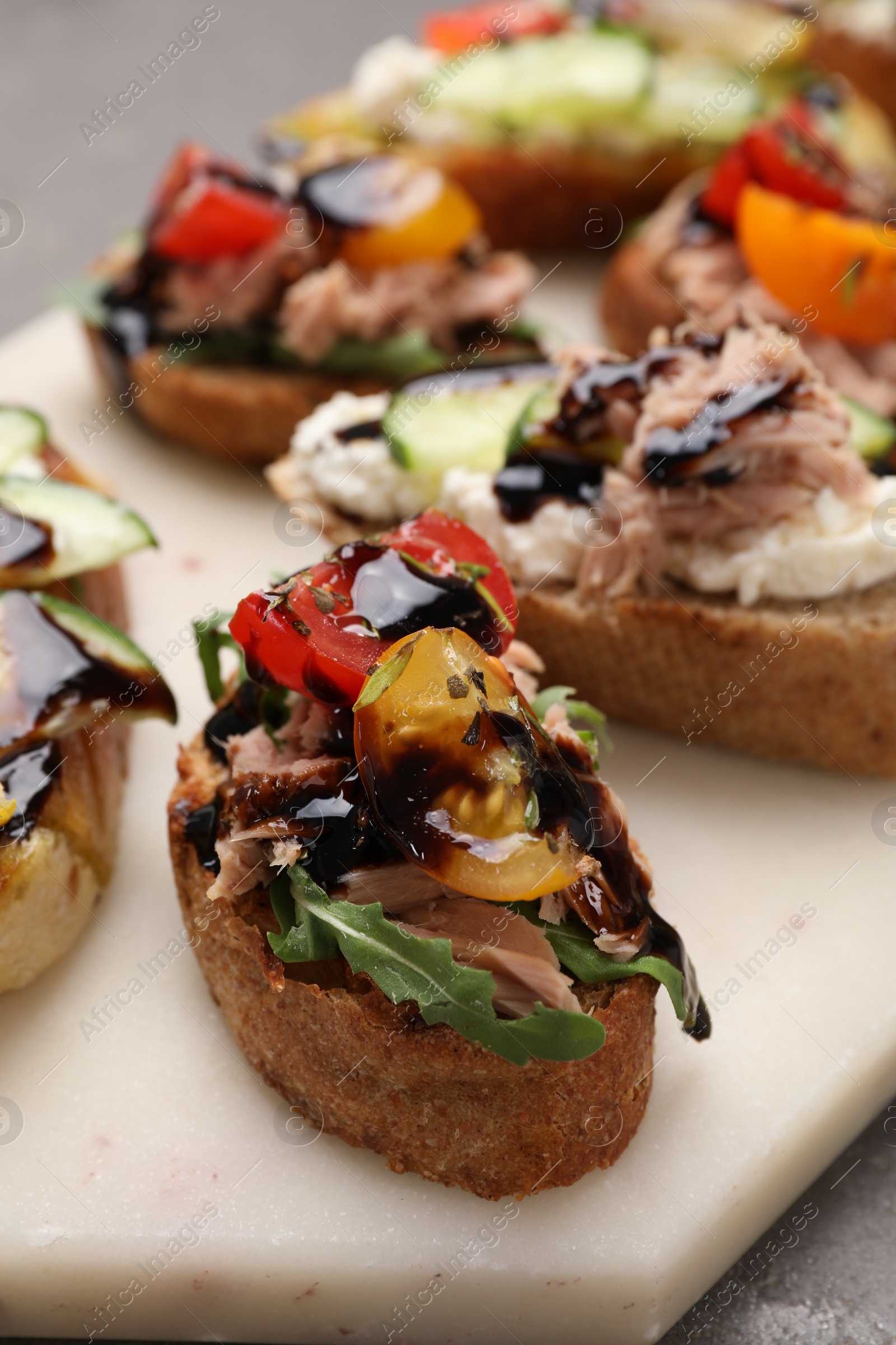 Photo of Delicious bruschettas with balsamic vinegar and different toppings on table