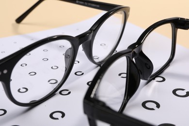 Photo of Vision test chart and glasses on table, closeup