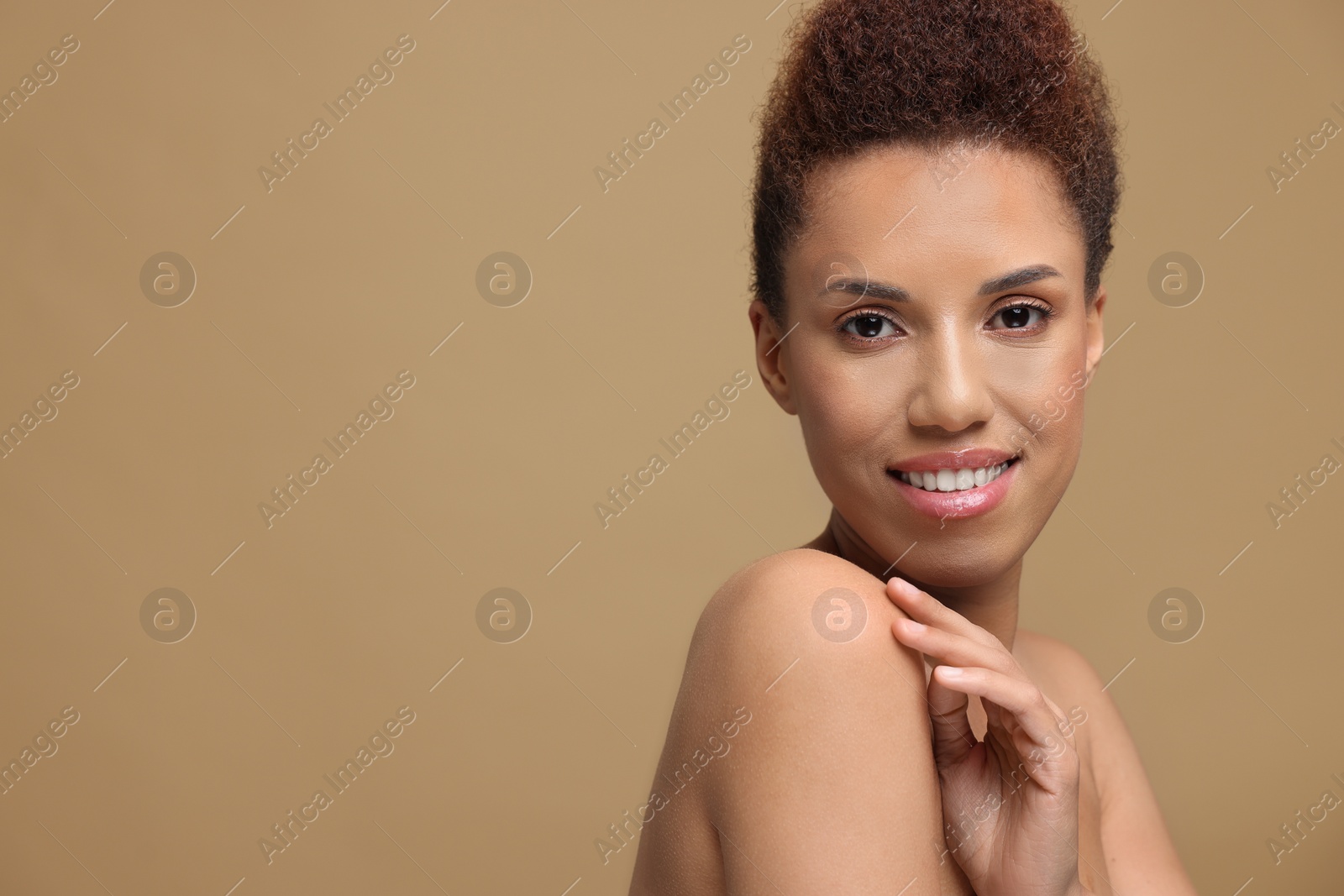 Photo of Portrait of beautiful young woman with glamorous makeup on light brown background. Space for text