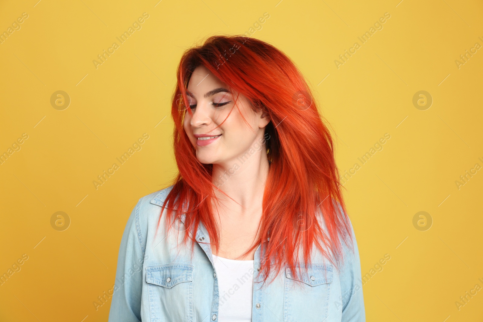 Photo of Young woman with bright dyed hair on yellow background