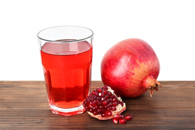 Photo of Refreshing pomegranate juice in glass, leaves and seeds on wooden table against white background