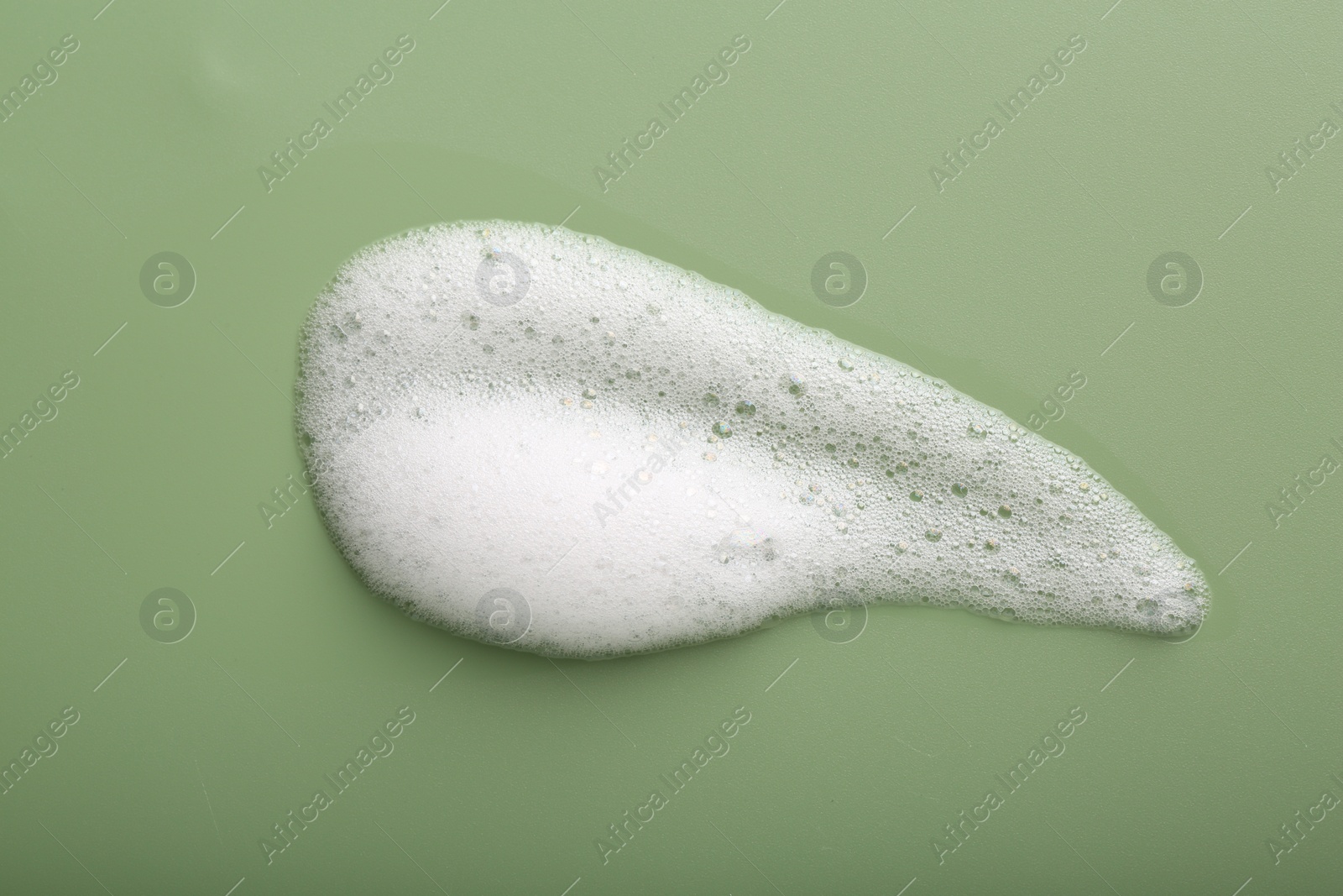 Photo of Sample of fluffy foam on green background, top view