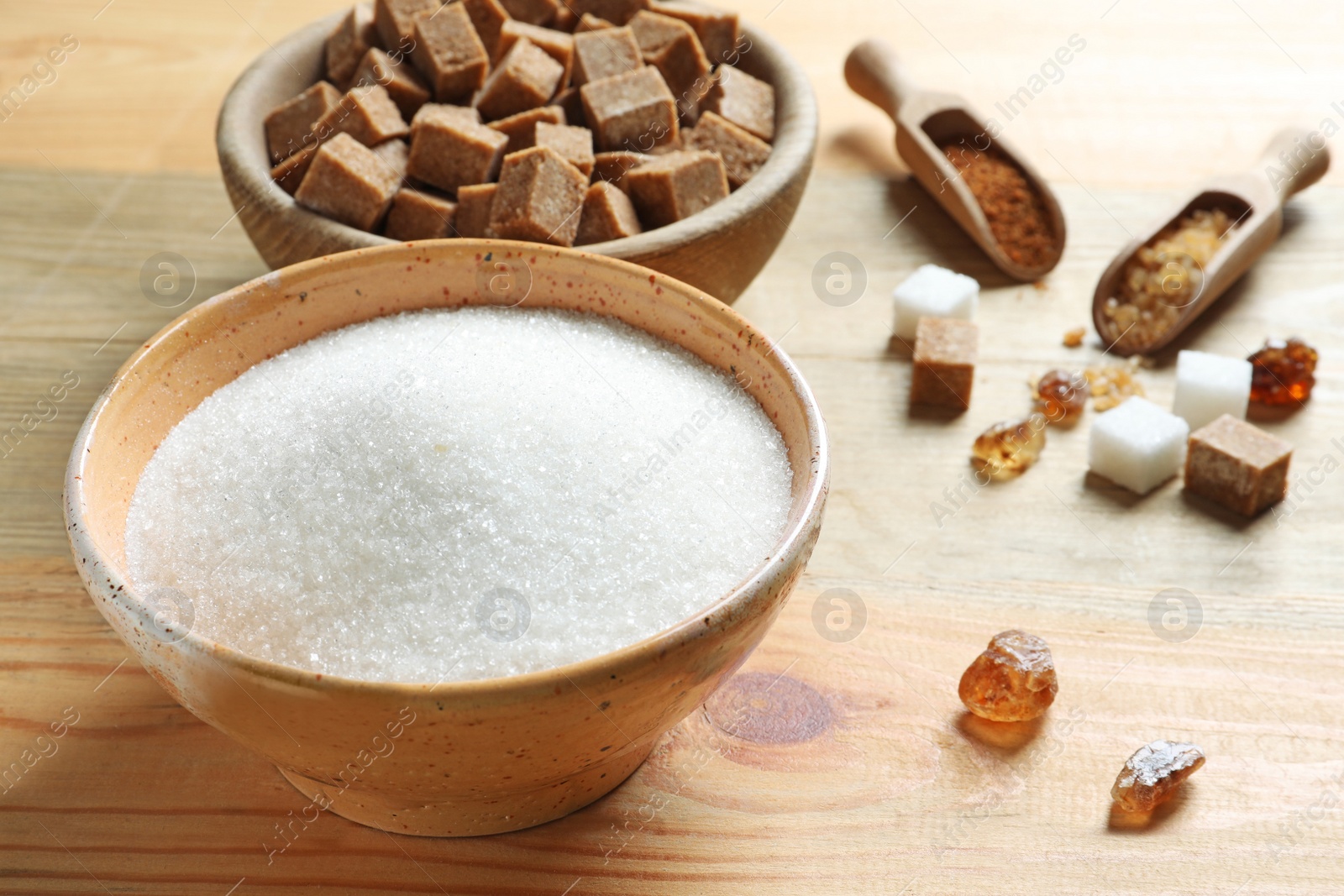 Photo of Bowl with white sugar on wooden background