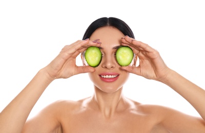 Young woman with silky skin after face mask holding cucumber on white background