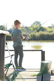 Photo of Little boy fishing alone on sunny day