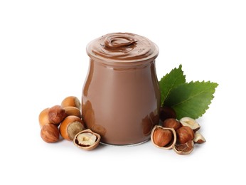 Glass jar with tasty chocolate hazelnut spread and nuts on white background