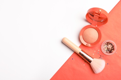 Photo of Flat lay composition with coral blush, glitter and makeup brush on color background. Space for text