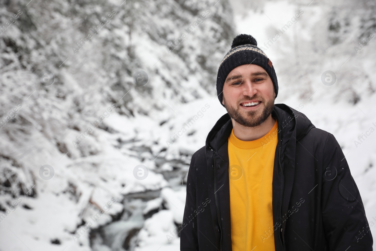 Photo of Handsome man wearing warm clothes outdoors on snowy day. Winter vacation