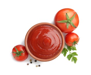 Tasty ketchup in bowl, parsley, peppercorns and fresh tomatoes isolated on white, top view