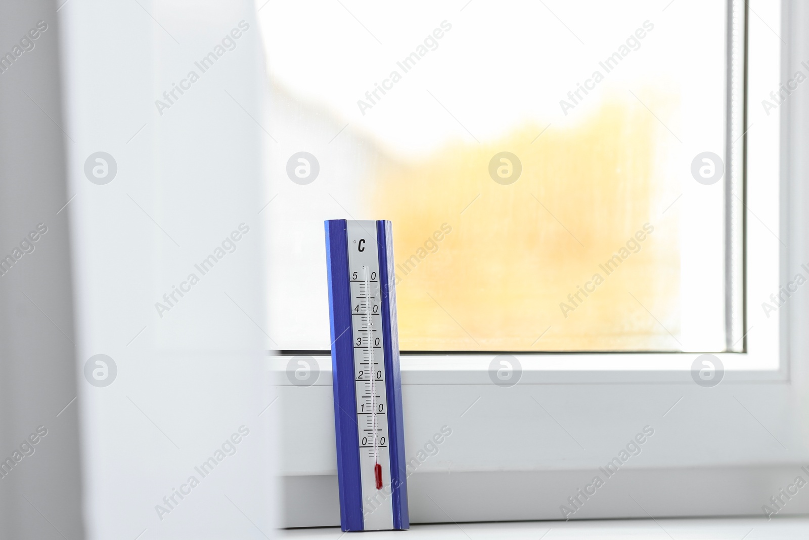 Photo of Weather thermometer on window sill indoors. Space for text