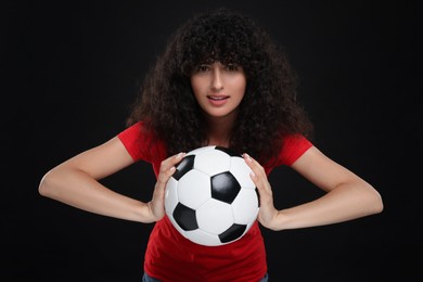 Photo of Fan holding soccer ball on black background