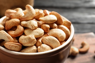 Photo of Bowl with cashew nuts on table, closeup