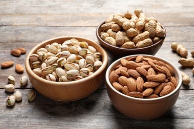 Bowls with organic nuts on wooden table. Snack mix