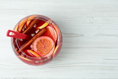 Photo of Glass bowl of aromatic punch drink on white wooden table, top view. Space for text