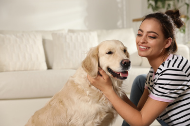 Photo of Young woman and her Golden Retriever at home. Adorable pet