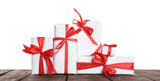 Many Christmas gifts on wooden table against white background