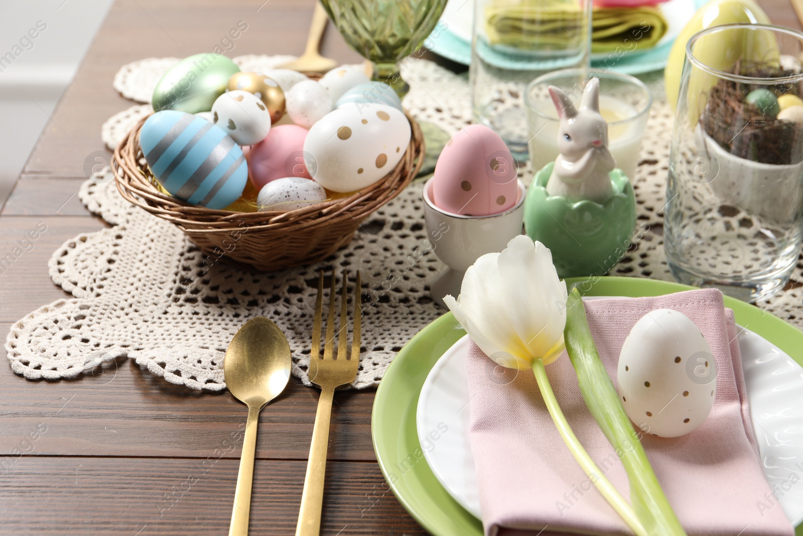 Photo of Festive table setting with painted eggs, closeup. Easter celebration