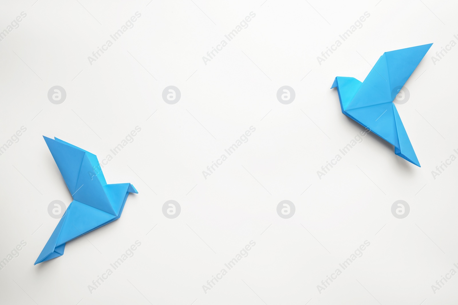 Photo of Beautiful blue origami birds on white background, flat lay. Space for text