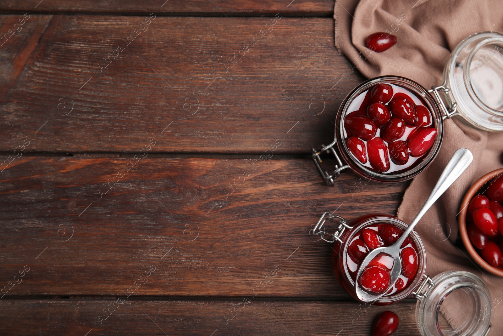 Photo of Delicious dogwood jam with berries on wooden table, flat lay. Space for text