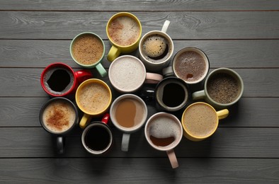 Photo of Many different cups with aromatic coffee on grey wooden table, flat lay
